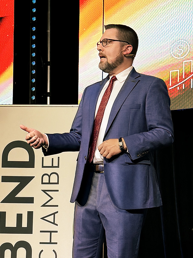 Mike Kingsella speaking on stage at a conference